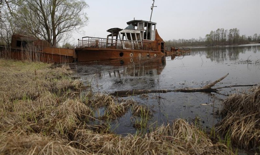 Una vieja lancha abandonada en el canal del río Pripyat en la Reserva Radioecológica Estatal dentro de la zona de exclusión a 30 kilómetros del reactor nuclear de Chernóbil, a algo más de 390 kilómetros de Minsk, Bielorrusia. EFE/Tatyana Zenkovich