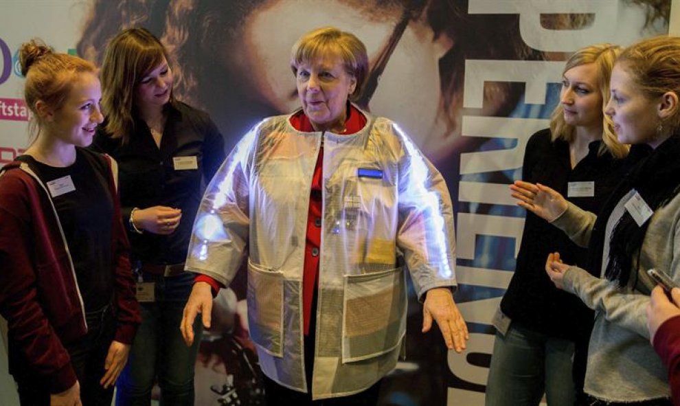 La canciller alemana, Angela Merkel, se prueba una chaqueta inteligente diseñada a prueba de carteristas y que informa de la temperatura durante el Día de las Chicas en la Cancillería Federal en Berlín, Alemania. EFE/Kay nietfeld