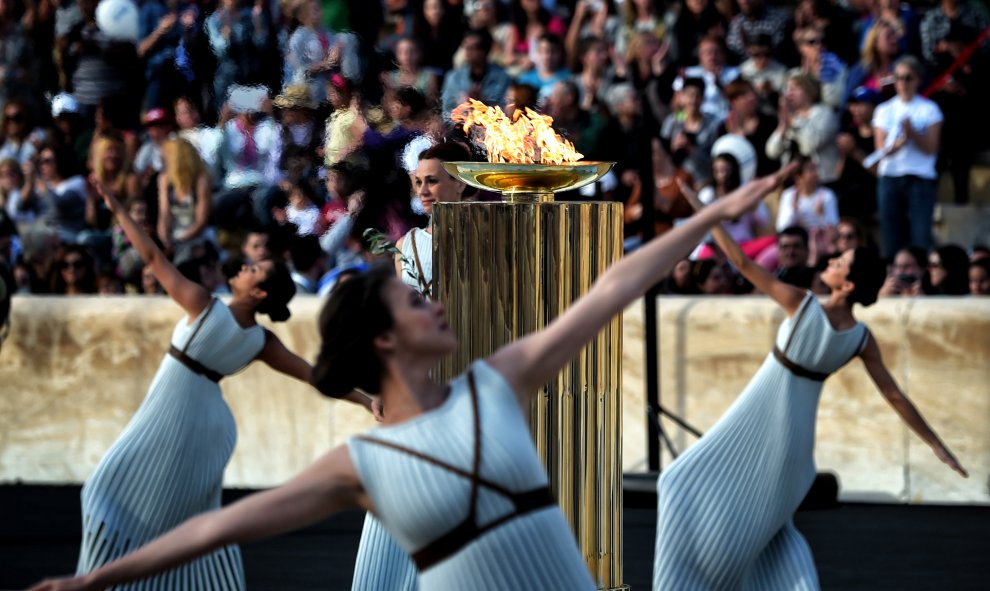 Sacerdotisas bailan alrededor de la llama olímpica durante la ceremonia de relevo en el Estadio Panathinaiko en Atenas. ARIS MESSINIS / AFP