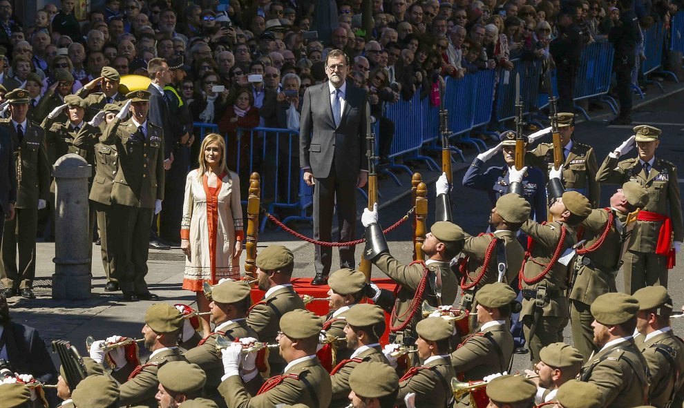 El presidente del Gobierno en funciones, Mariano Rajoy, y la presidenta de la Comunidad de Madrid, Cristina Cifuentes, escuchan el himno durante la tradicional parada y desfile militar que se ha celebrado en la Puerta de Sol, con motivo del Día de la Comu