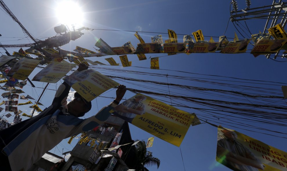 Un activista coloca carteles electorales en una calle de Manila, Filipinas. EFE/Ritchie B. Tongo