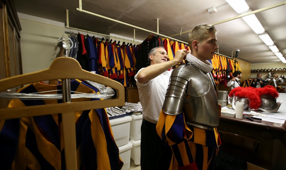 Un nuevo guardia suizo del Vaticano es ayudado a ajustar su uniforme antes de la ceremonia de toma de posesión en el Vaicano. REUTERS / Stefano Rellandini