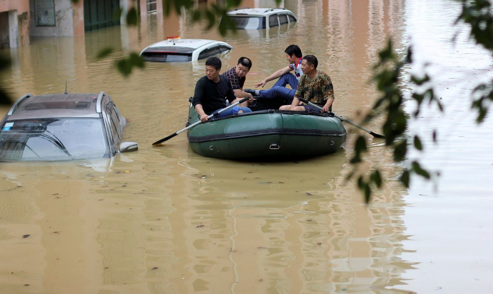 Personas remando en un bote en una zona inundada después de fuertes lluvias en Yongzhou, provincia de Hunan, China. REUTERS / Stringe