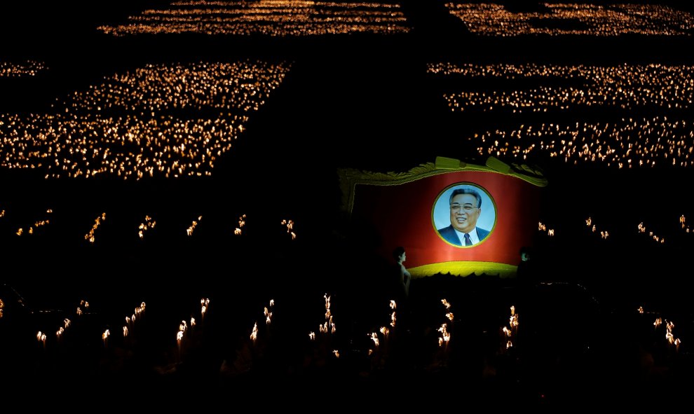 Los participantes llevan antochares y una imagen del ex lídero norcoreano Kim Il Sung durante una procesión de antorchas en la plaza principal de la capital, un día después de la fiesta del Partido del Trabajo de Corea concluyó su primer congreso en 36 añ