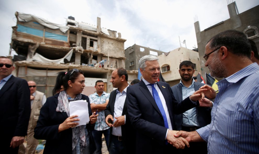 El ministro belga de Asuntos Exteriores , Didier Reynders, da la mano a un palestino cuya casa fue destruida durante la guerra de Gaza de 2014. REUTERS / Mohammed Salem