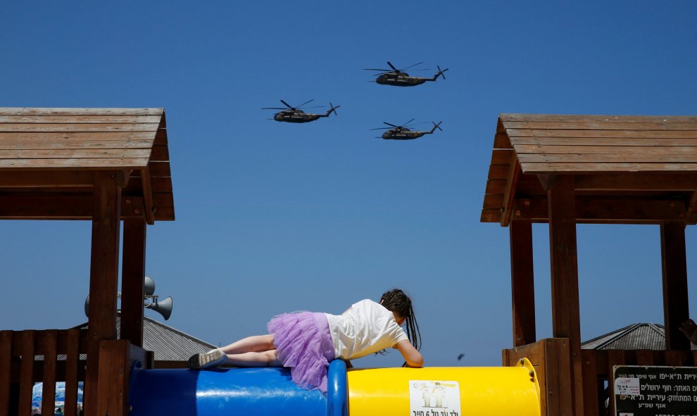 Una niña mira como helicópteros de la Fuerza Aérea de Israel vuelan sobre el mar Mediterráneo durante las celebraciones para el Día de la Independencia de Israel en Tel Aviv. REUTERS/Baz Ratner