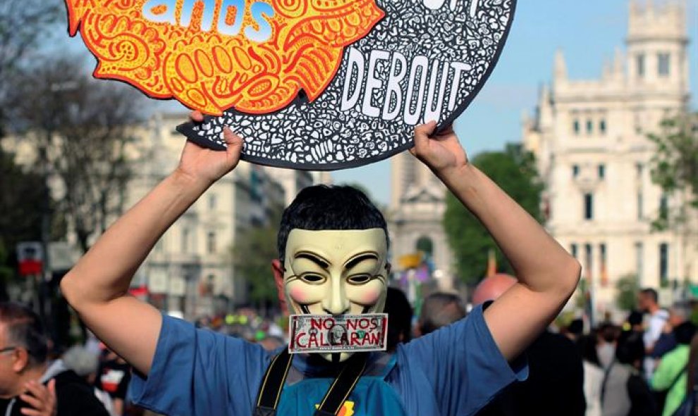 Uno de los participantes en la manifestación entre la Plaza de Cibeles y la Puerta del Sol para conmemorar el quinto aniversario del movimiento 15-M.- EFE/Ana Márquez