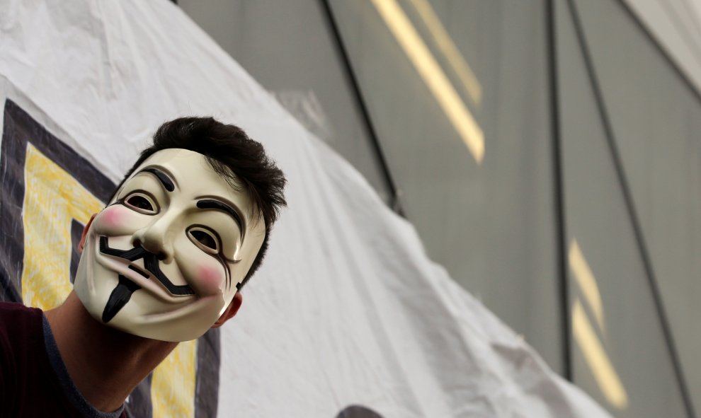 A man wears a Guy Fawkes mask as he attends a march to mark the 5th anniversary of the "indignados" movement in Madrid, Spain, May 15, 2016. REUTERS/Sergio Perez