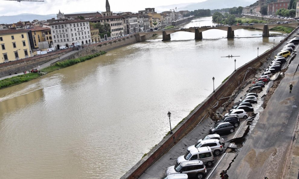 Varios vehículos aparecen engullidos por un socavón cerca del famoso Puente Viejo a orillas del río Arno, en el centro de la ciudad italiana de Florencia (Italia). EFE/Maurizio Degl' Innocenti