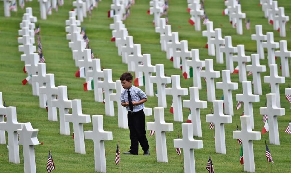 Un niño camina junto a varias tumbas en el Cementerio Militar americano en Falciani, a las afueras de Florencia en Italia, durante la ceremonia en honor al día de los caídos, que conmemora a todos los hombres y mujeres estadounidenses que murieron durante
