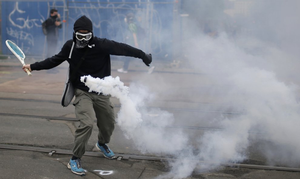 Un manifestante usa una raqueta de tenis para devolver una granada de gas lacrimógeno durante una manifestación para protestar contra la reforma laboral del Gobierno francés en Nantes, Francia. REUTERS/Stephane Mahe