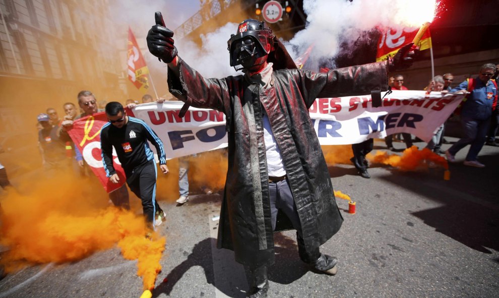 Un trabajador del acero equipado con un traje protector y una máscara de Darth Vader de Star Wars, porta bengalas durante una manifestación de protesta contra la reforma laboral del Gobierno galo en Marsella, Francia.  REUTERS/Jean-Paul Pelissier