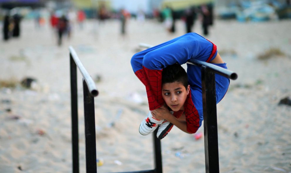 Mohamad al-Sheikh, un niño contorsionista palestino de 12 años, apodado Spiderman intenta lograr el récord Guinnes del mundo con sus demonstraciones acrobáticas y contorsionistas en una playa de Gaza. REUTERS/Mohammed Salem
