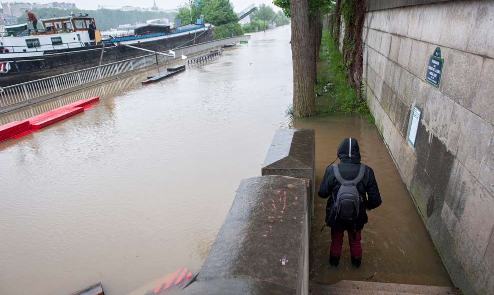 Un peatón se acerca a observar de cerca la crecida del río Sena. / EFE