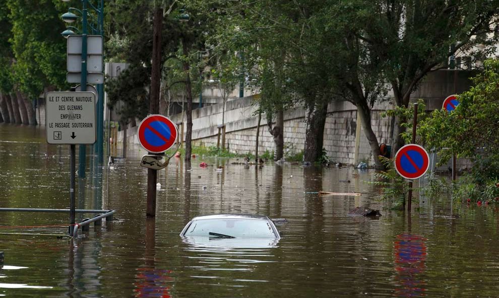 Hasta los coches y las señales de tráfico han sucumbido al furor de las aguas. / REUTERS