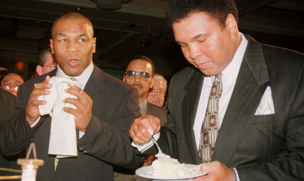 Mohamed Ali/Cassius Clay toma un trozo de su pastel de cumpleaños junto al boxeador Mike Tyson en el MGM Grand hotel de  Las Vegas, el 17 de enero de 1999. REUTERS/Teddy Blackburn