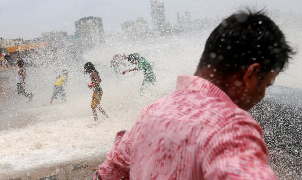 Un grupo de personas de mojan con el impacto de una ola en Mumbai, India. REUTERS/Danish Siddiqui