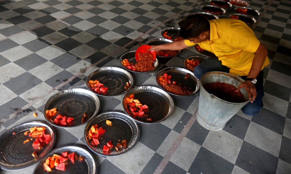 Un musulmán prepara platos de comida para el Iftar en una mezquita en el primer día de Ramadan en India. REUTERS/Rupak De Chowdhuri