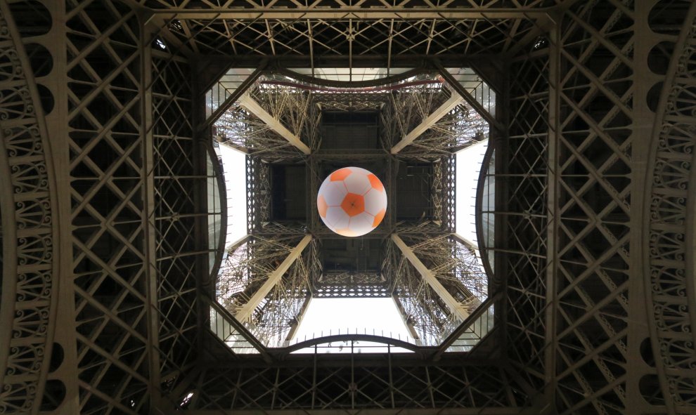 Un balón de fútbol gigante se suspende bajo la Torre Eiffel, con motivo de la clebración de la Eurocopa.REUTERS / Pawel Kopczynski