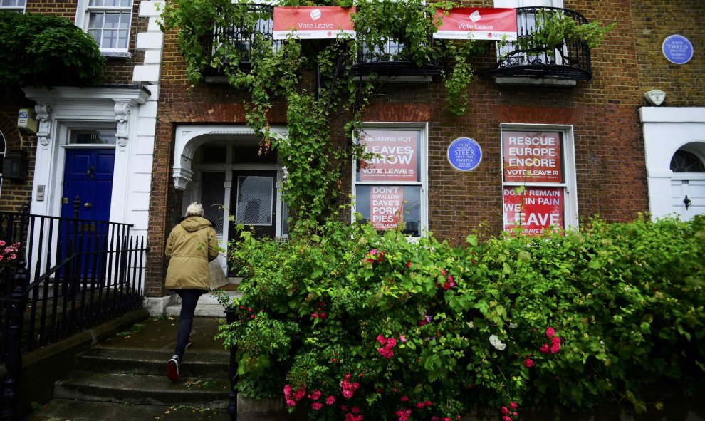 Una persona que apoya el Brexit, llega a su casa decorada con pancartas favorables al mismo en Londres, Reino Unido. REUTERS/Dylan Martinez