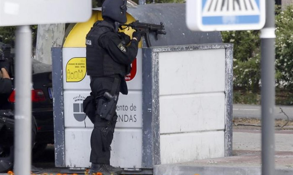 Un agente en el exterior de un restaurante chino de la localidad madrileña de Alcobendas donde un inspector de Policía se ha atrincherado, amenaza con suicidarse y no deja acercarse a nadie. EFE/J. J. Guillén