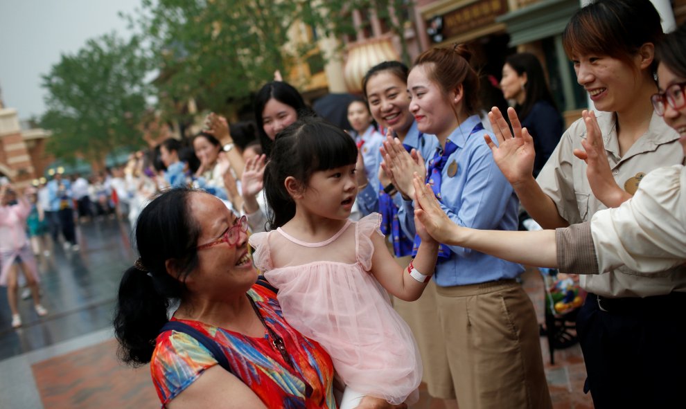 Una niña recibe la bienvenida del personal del Resort de Disney en Shangai al momento de su apertura
