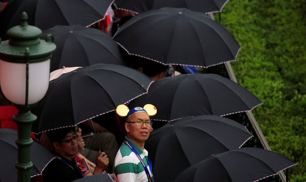 Un hombre con las orejas de Mickey Mouse mira expectante la gala de inauguración