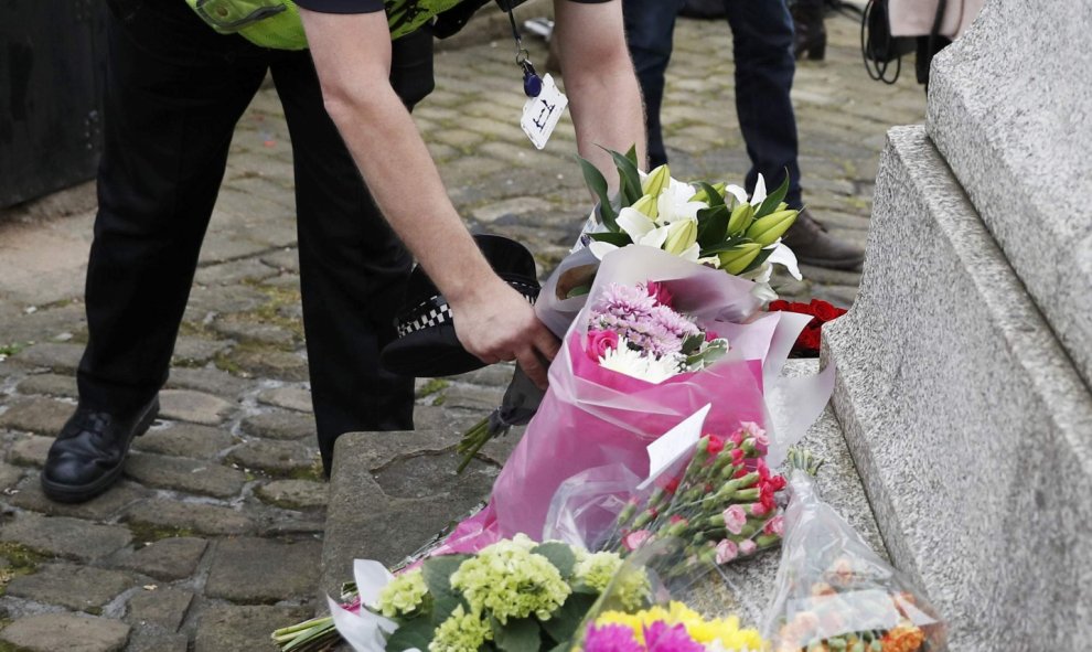 Un policía deja flores en el Birstall, el lugar del crimen de la diputada laborista