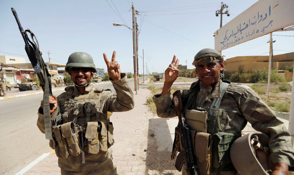 Soldados iraquíes saludan en el centro de Faluya, Irak. REUTERS/Thaier Al-Sudani