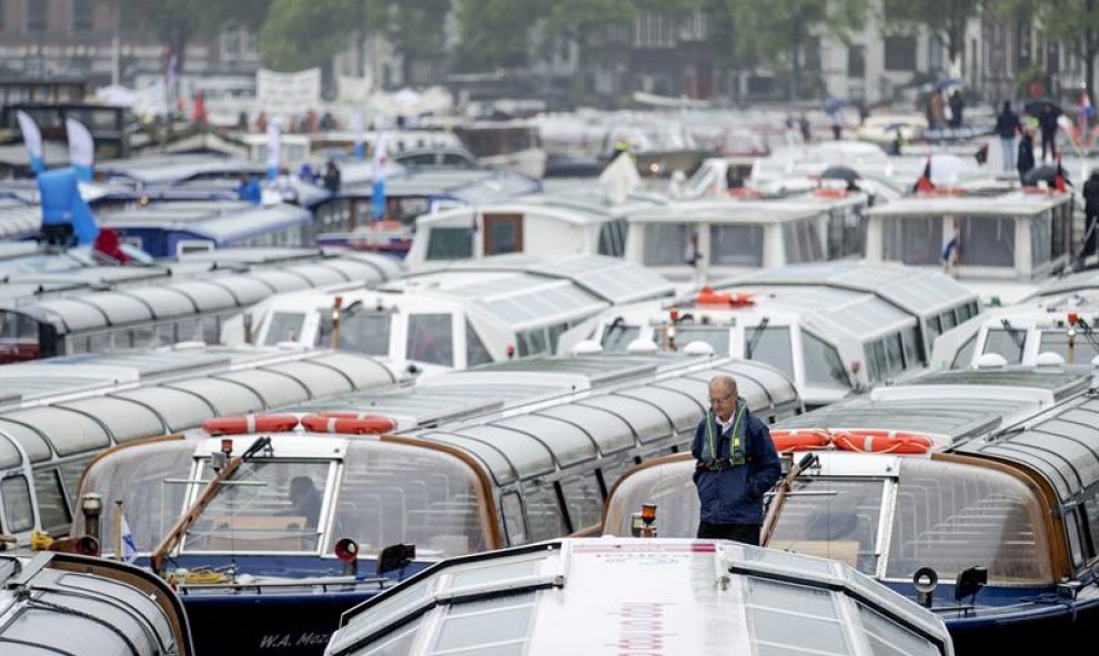 Vista general de varios barcos turísticos que bloquean uno de los canales de Ámsterdam, Holanda. EFE/Robin Van Lonkhuijsen