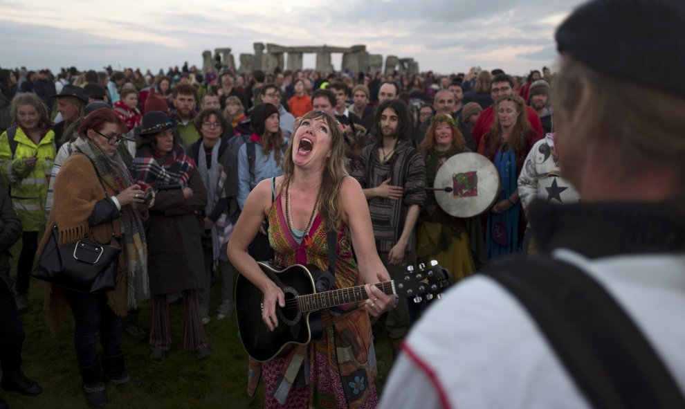 Una mujer cantando seguida por una multitud muy variada en Stonehenge
