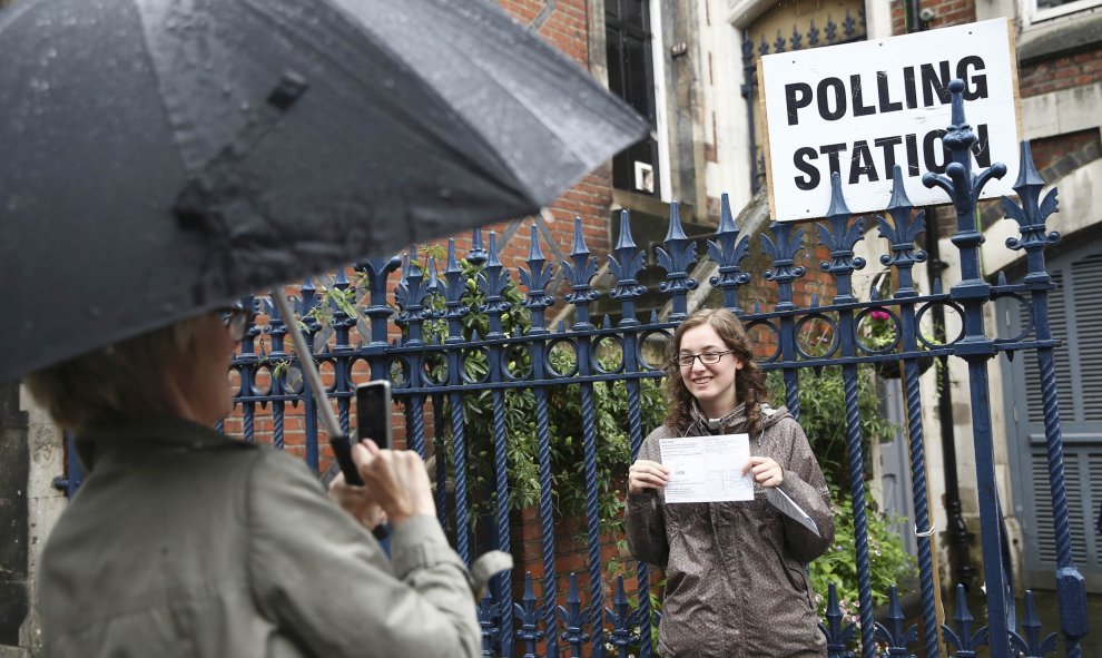 Una chica posa para una foto con la papeleta de voto a la salida de un colegio electoral en Reino Unido