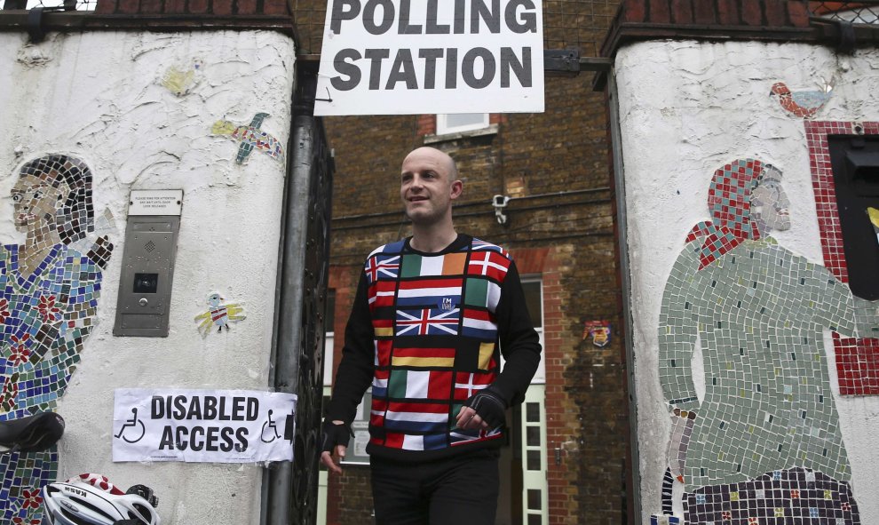 Un chico con un jersey con banderas europeas y una pegatina que dice "I'm in" ('estoy dentro') sale del colegio electoral en Reino Unido/REUTERS