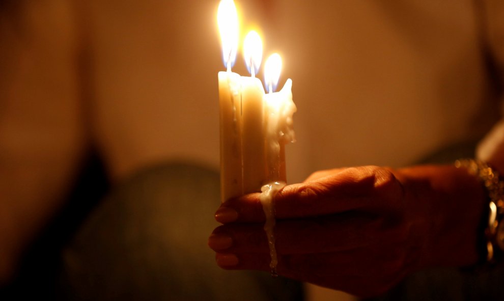 Una mujer enciende velas durante una vigilia en solidaridad con los soldados jordanos asesinados en un ataque contra un puesto militar fronterizo cerca de un campamento de refugiados sirios, en Amman. REUTERS/Muhammad Hamed