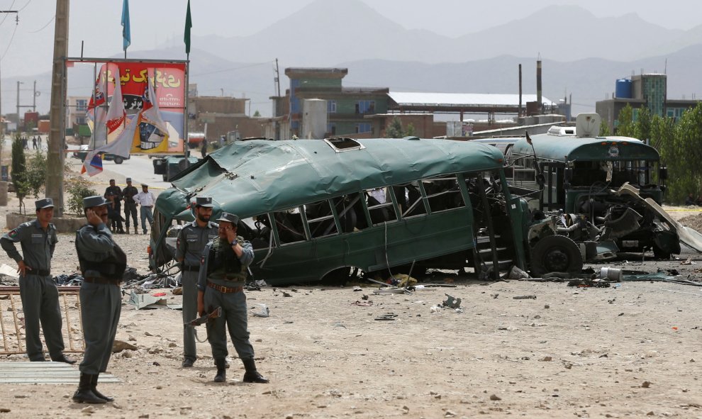 Fuerzas de seguridad afganas inspeccionan los daños en los autobuses dañados por atacantes suicidas en las afueras de Kabul, Afganistán.- REUTERS / Omar Sobhani