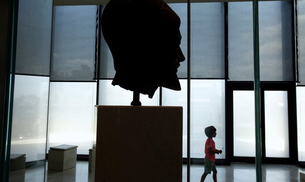 Un joven turista camina frente a una cabeza de bronce datada del 470-480 AC de un hoplita barba ( soldado ) en el interior del Museo de la Acrópolis en Atenas , Grecia.-  REUTERS / Yannis Behrakis