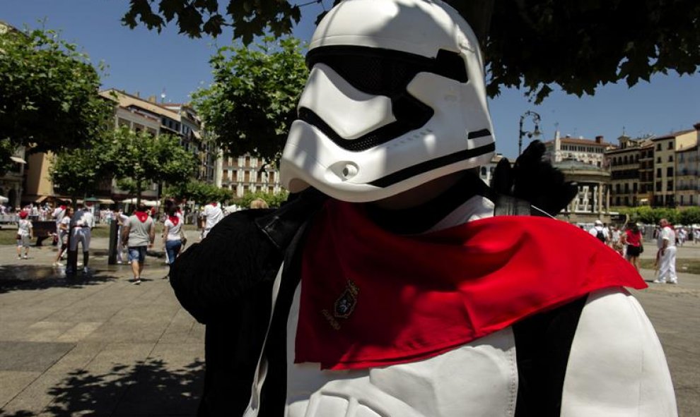 Un hombre disfrazado de soldado del Imperio Galáctico de Star Wars se coloca el tradicional pañuelico rojo al cuello para sumarse a la fiesta durante los Sanfermines 2016. EFE/Villar López.