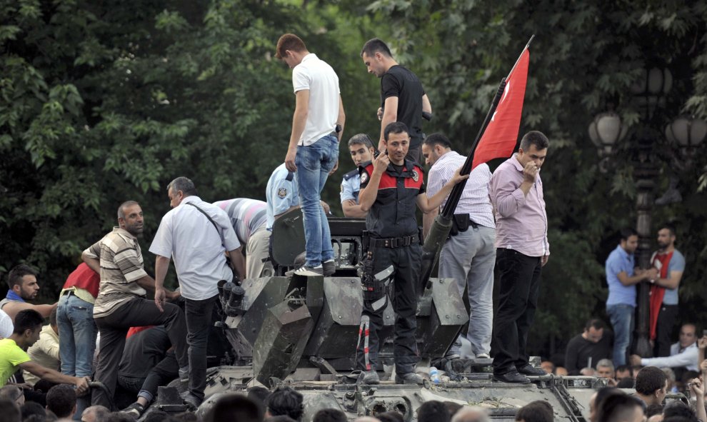 Un policía turco y varios civiles sobre de un vehículo militar en Ankara, tras el intento de golpe de Estado militar en Turquía.- REUTERS