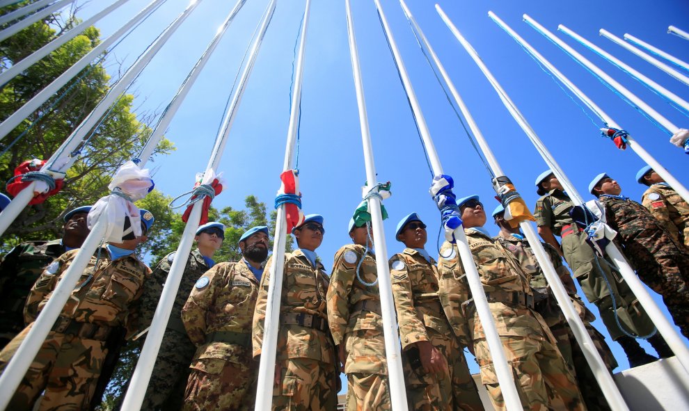 Los miembros de las Fuerzas de la Paz del Líbano posan de pie junto a sus banderas plegadas en la sede de las Naciones Unidas situada en Naqoura, al sur del Líbano. REUTERS/Ali Hashisho