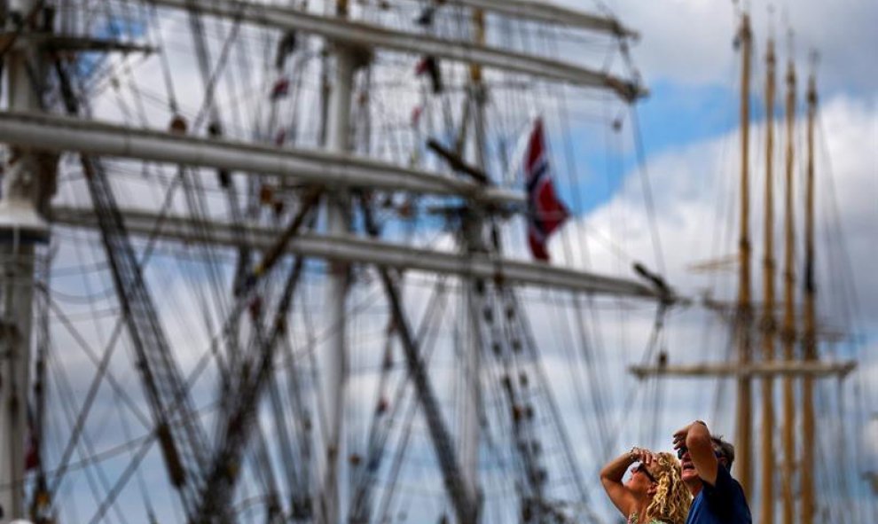 Dos visitantes observan los barcos de vela atracados en el muelle Santa Apolonia en el ámbito de las regatas de barcos de vela en Lisboa (Portugal). El evento celebra su 60º aniversario este año. EFE/Mario Cruz