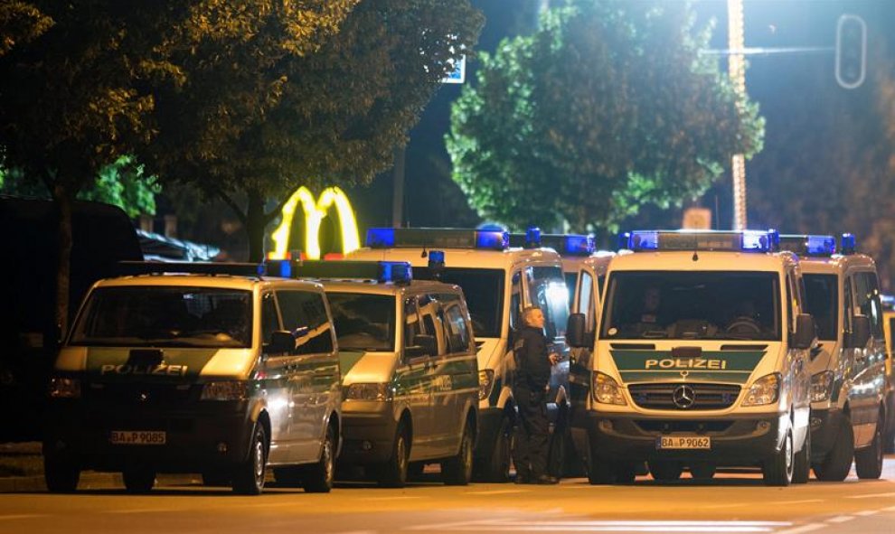 Furgones policiales junto a la hamburguesería donde se produjo el tiroteo. - EFE