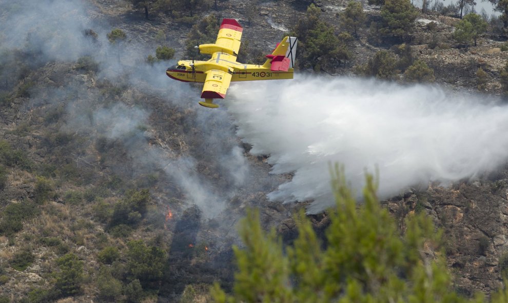 Medios aéreos trabajan en la extinción del incendio en el Parque Natural de la Serra d'Espadá en Artana (Castellón), que ha afectado hasta el momento mil hectáreas y está en proceso de estabilización, gracia a las labores de extinción y a la mejor climato