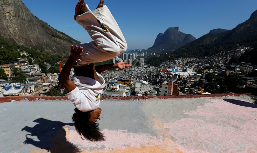 Un miembro del grupo Acorda Capoeira practica en el tejado de un edificio de la favela Rocinhab en Rio de Janeiro, Brasil. REUTERS/Bruno Kelly