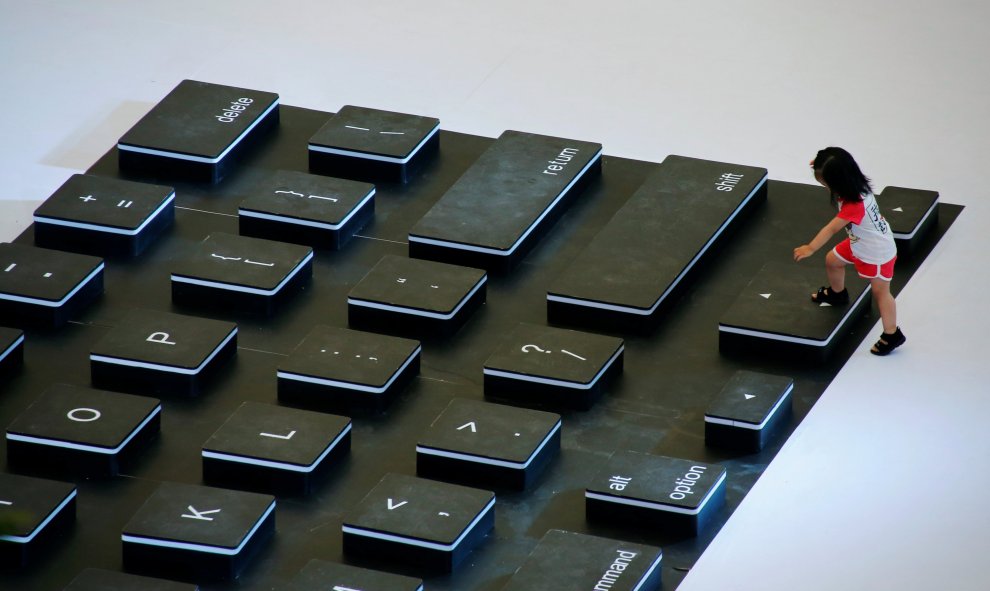 Una niña se sube a un teclado gigante durante un evento de promoción en un centro comercial de Pekín. REUTERS/Thomas Peter