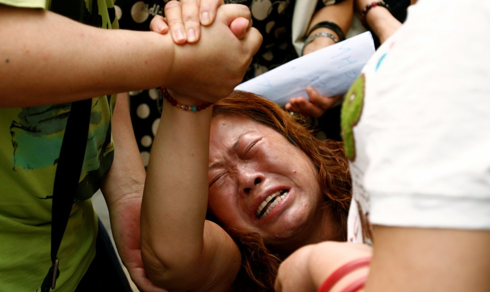 La familiar de un pasajero que viajaba a bordo del vuelo MH370 de Malaysia Airlines, que desapareció en 2014 reacciona durante una protesta frente al Ministerio de Asuntos Exteriores chino en Pekín. REUTERS/Thomas Peter
