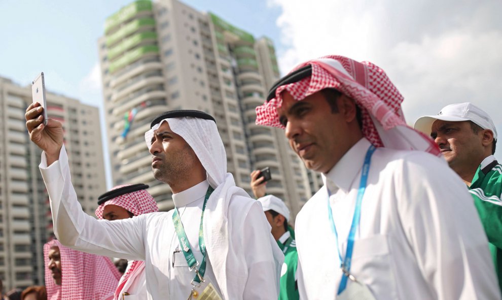 Miembros de la delegación de Arabia Saudí fotografían la Villa Olímpica durante un paseo. /REUTERS