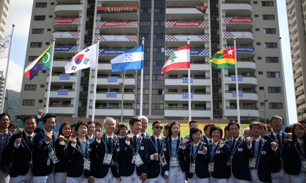 El equipo coreano junto a varias banderas y los edificios de la Villa, de fondo. /REUTERS