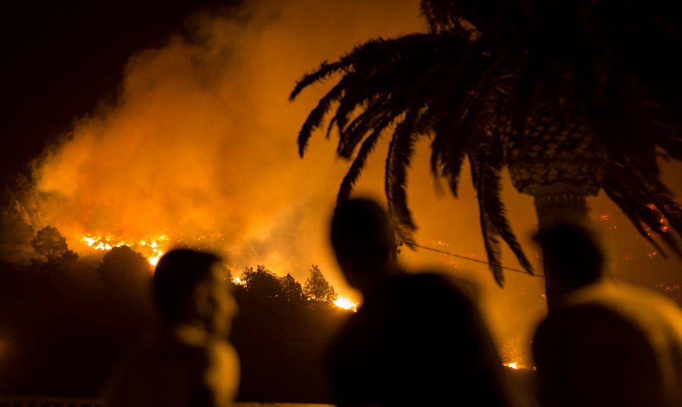 Un grupo de gente contempla como el fuego arde sin control en Las Manchas, en la isla de Palma. REUTERS/Borja Suarez