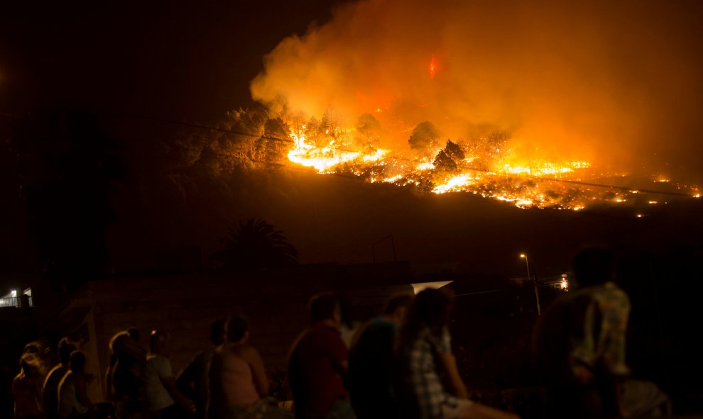 Un grupo de gente ve cómo el incendio avanza sin control en Las Manchas, al suroeste de la isla de La Palma. REUTERS/Borja Suarez