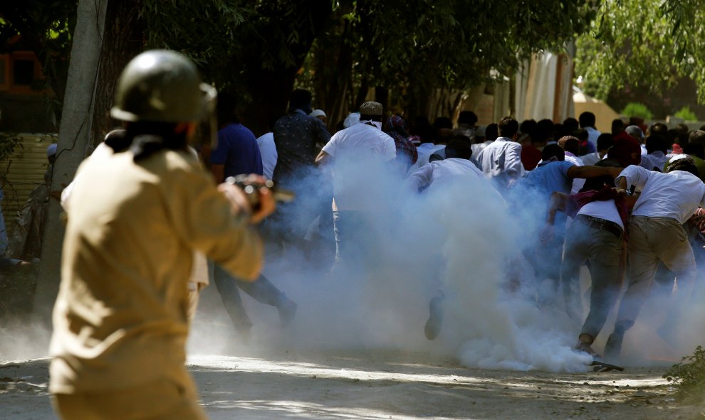 Manifestantes huyen ante un policía que dispara gases lacrimógenos durante una manifestación contra los recientes asesinatos en Cachemira, en las afueras de Srinagar. REUTERS/Danish Ismail